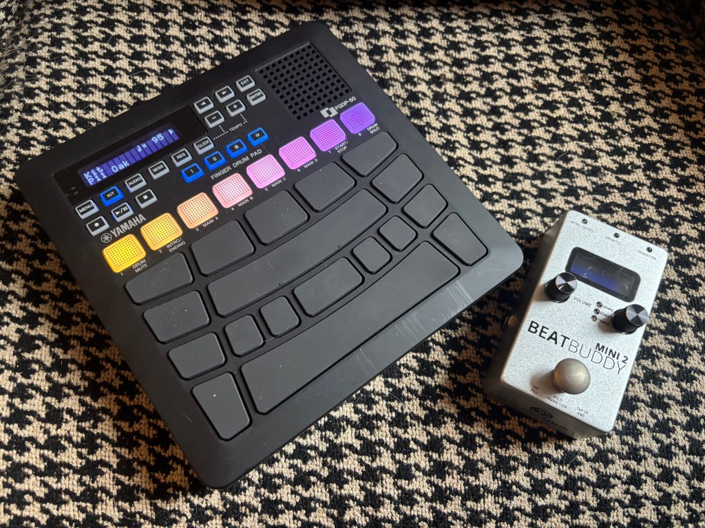 Pictured: houndstooth, dog hair, and two modern percussion tools used in the creation of The Night Wrecker--A Yamaha FGDP-50 finger drum pad and a Beat Buddy Mini2. 